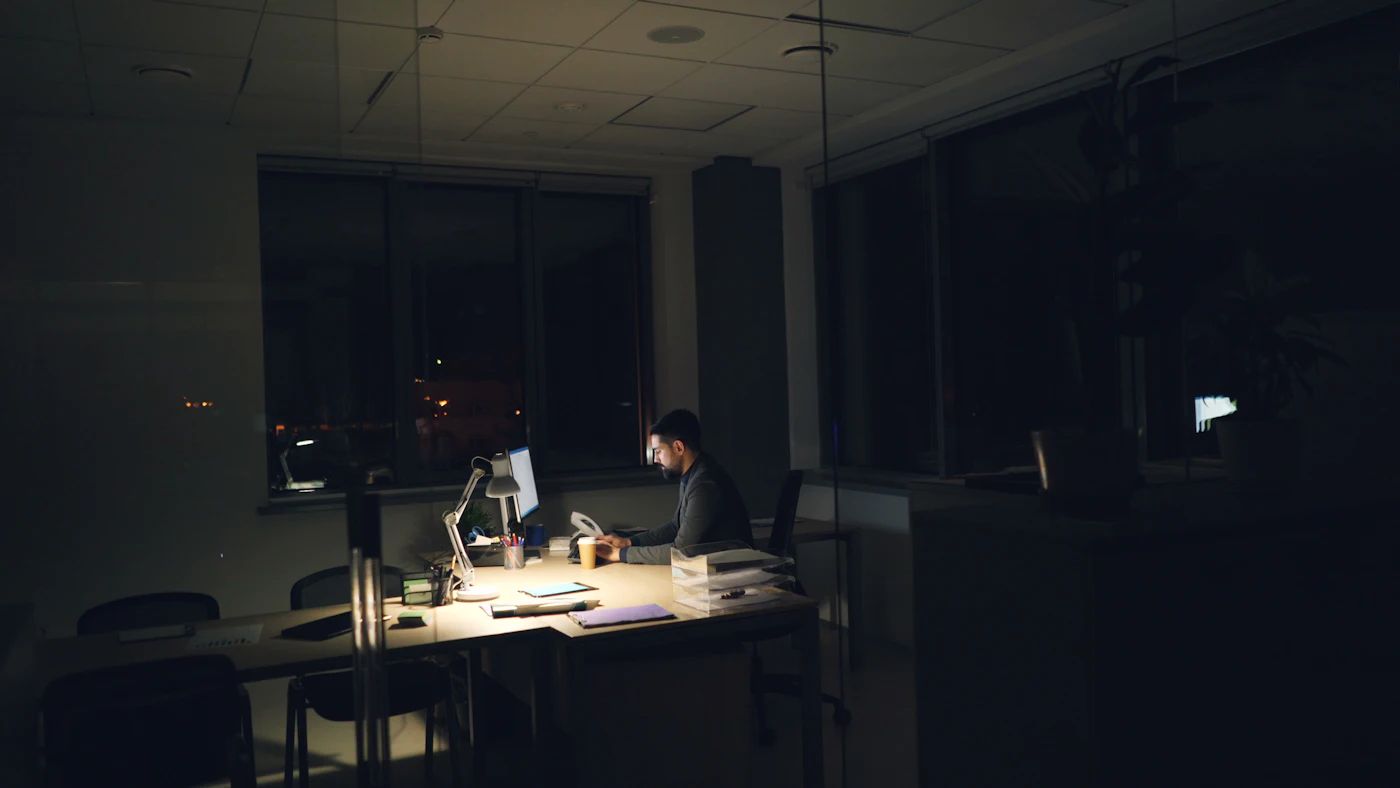 Una persona al lavoro alla scrivania a fine giornata